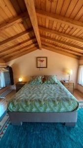 uma cama grande num quarto com tecto em madeira em Alpendre em Guimarães