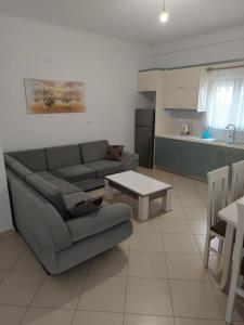 een woonkamer met een bank en een tafel en een keuken bij Villa Kleo Ksamil in Ksamil
