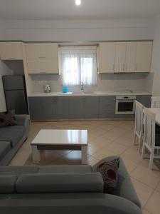 een keuken met een bank en een tafel in de woonkamer bij Villa Kleo Ksamil in Ksamil