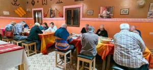 um grupo de pessoas sentadas em mesas em um restaurante em Riad Dades Birds em Boumalne Dadès