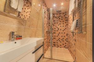 een badkamer met een wastafel en een douche bij Maestro Hotel in Baku