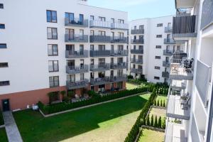 apartamentowiec z trawnikiem przed nim w obiekcie Apartments Space and More, Dmowskiego - 20 minut do RYNKU, Self Check-In 24H, Parking we Wrocławiu