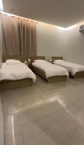 zwei Betten in einem Zimmer mit weißen Wänden in der Unterkunft Hotel Apartment - 12 - LAvner Al Moteab in Riad