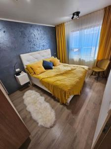 een slaapkamer met een bed met een gele deken en een tapijt bij Flat in Akureyri in Akureyri