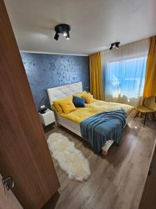 een slaapkamer met een bed met gele lakens en een tapijt bij Flat in Akureyri in Akureyri
