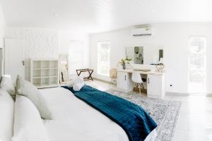 1 dormitorio blanco con 1 cama grande con manta azul en Huis Marais en Heroldsbaai