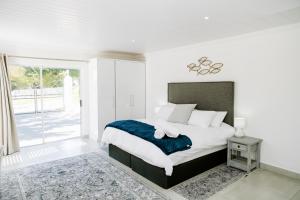 a bedroom with a large bed and a window at Huis Marais in Herolds Bay