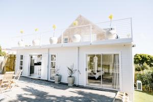 uma casa branca com portas de vidro deslizantes em Huis Marais em Herolds Bay