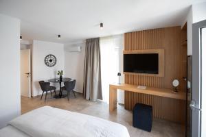 a hotel room with a bed and a desk with a television at Griffin Suites in Heraklio