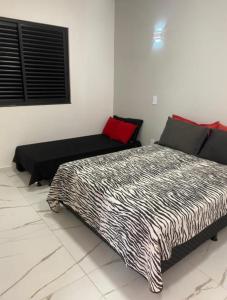 ein Schlafzimmer mit einem Bett und einem Sofa in der Unterkunft Rancho Teixeira in Alexânia