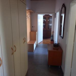 斯科普里PORTA CENTER APARTMENT的通往厨房的走廊，厨房里有一张桌子和橱柜