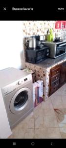 a kitchen with a washing machine and a microwave at Charmante maison de campagne in Temara