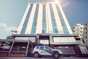 um carro branco estacionado em frente a um edifício em Fesa Business Hotel em Gebze