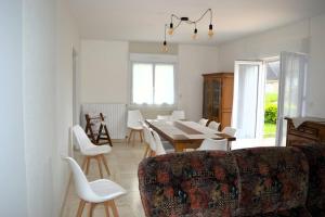 un salon avec une table, des chaises et un canapé dans l'établissement Le Dortoir, maison familiale - jardin - 5km mer, à Cresserons