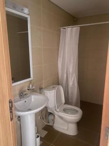 a bathroom with a white toilet and a sink at Golf Mews Inspired Living in Benin City