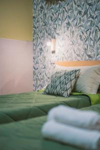 um quarto com uma cama verde e uma parede em Apulia Rooms Bari em Bari