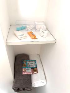 a shelf in a bathroom with a book and towels at Friendly Apartment Tamayo in Lima