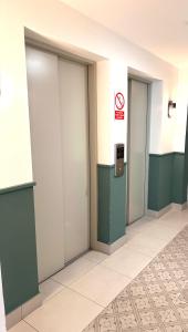 Friendly Apartment Tamayo في ليما: ثلاثة أبواب مصعد في مبنى لا يسمح بالتدخين فيه