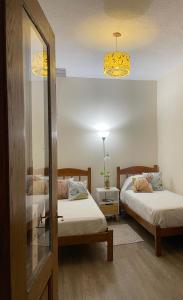 um quarto com 2 camas, 2 candeeiros e um espelho em Habitación privada en apto cat friendly em Montevidéu