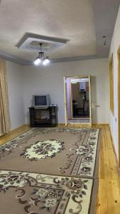 Sheki Guest House في شيكي: غرفة معيشة مع سجادة على الأرض