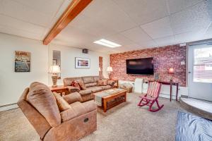 a living room with a couch and a brick wall at Cozy Apartment Less Than 4 Miles to Downtown Anchorage! in Anchorage