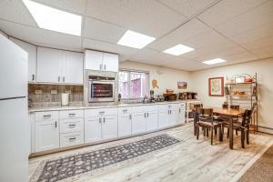 Cozy Apartment Less Than 4 Miles to Downtown Anchorage! في أنكوراج: مطبخ بدولاب بيضاء وطاولة خشبية
