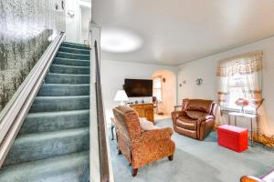 a living room with a staircase and a chair at Charming West Mifflin House - 3 Mi to Kennywood! in West Mifflin