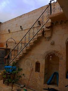 a stone building with a staircase and a playground at Alkan konuk evi in Urfa