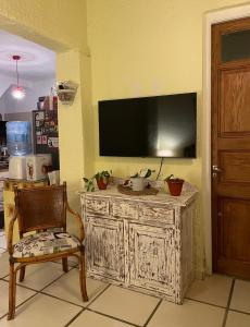 um quarto com uma televisão numa parede com uma cadeira em Habitación privada en apto cat friendly em Montevidéu