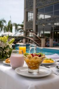 a table with a bowl of fruit and a drink at Amérian Hotel Casino Carlos V in Termas de Río Hondo