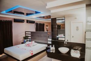 a bedroom with a large white bed and a mirror at Luxury Motel in Sorocaba