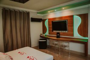 a hotel room with a flat screen tv on a wall at Luxury Motel in Sorocaba