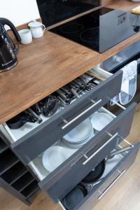 a kitchen drawer with plates and dishes in it at Epiphany homes - 4 bedroom house in Norwich - Contractor friendly - close to airport and hospital in Norwich