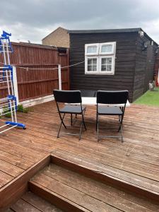 two chairs sitting on a wooden deck at Modern 3 Bed House for 6 guests in Nevendon