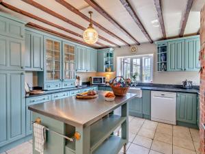 uma cozinha com armários azuis e uma mesa em 6 Bed in Ventnor 94745 em Wroxall