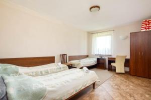 a bedroom with two beds and a desk and a table at Dom Wypoczynkowy Zalesie in Przanowice
