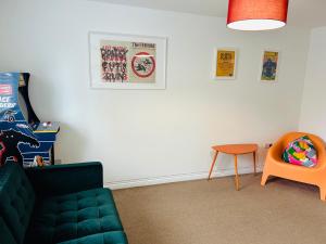een woonkamer met een groene bank en een stoel bij East London Apartment near Station & Free Parking, Arcade Machine in Romford