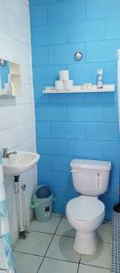 a blue bathroom with a toilet and a sink at Mini casa a dos cuadras de la playa, en medio del comercio local in La Libertad