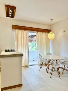 a dining room with a table and chairs and a window at Manay Preá, apartamento 2 quartos na melhor localização do Preá in Cruz