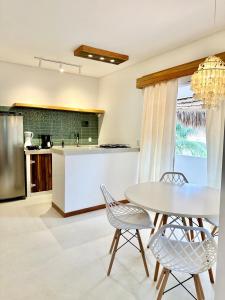 a kitchen with a table and chairs and a counter at Manay Preá, apartamento 2 quartos na melhor localização do Preá in Cruz