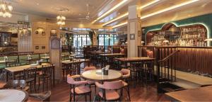 a restaurant with tables and chairs and a bar at 3 Bedroom in the Heart of West End in London