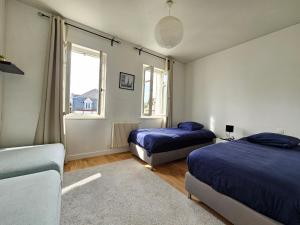 um quarto com 2 camas e uma janela em DEAUVILLE Maison plein centre, ideale famille ! em Deauville