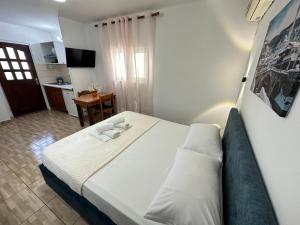 a bedroom with a large bed and a kitchen at Anel Studios in Vlorë