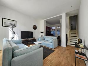 uma sala de estar com dois sofás e uma televisão em DEAUVILLE Maison plein centre, ideale famille ! em Deauville