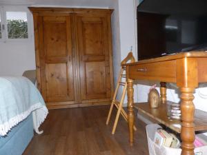 ein Schlafzimmer mit einem Holzschrank und einem Schreibtisch in der Unterkunft Sweet Home in Murten
