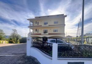 a white building with a fence in front of it at Pens&atilde;o Repouso do Peregrino in Paredes de Coura