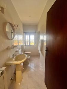 a bathroom with a sink and a toilet and a mirror at Pens&atilde;o Repouso do Peregrino in Paredes de Coura