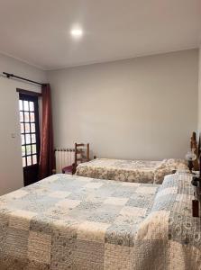 1 dormitorio con 2 camas y ventana en Pensão Repouso do Peregrino, en Paredes de Coura