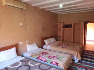 a bedroom with two beds with flowers on them at Dar Zara in Ouarzazate