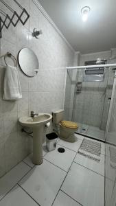 La salle de bains est pourvue de toilettes, d'un lavabo et d'une douche. dans l'établissement Quintal do forte, à Praia Grande